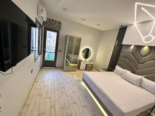 a bedroom with a bed and a television and a hallway at MidtownTahrirViewSuites in Cairo