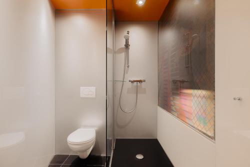 a bathroom with a toilet and a glass shower at Leonardo Boutique Hotel Maastricht City Center in Maastricht