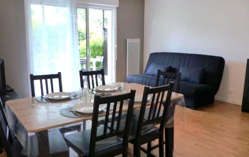une salle à manger avec une table, des chaises et un canapé dans l'établissement TY BIHAN - T2 - Wifi - Parking - Terrasse, à Séné