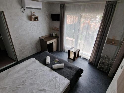 バルチクにあるGuest House Simon Greenのベッドルーム1室(ベッド1台、デスク、窓付)