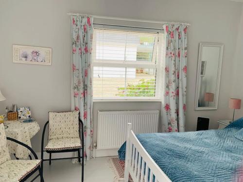 a bedroom with a bed and a window and a chair at Carol's Cottage (Studio Apt) - Wild Atlantic Way in Kilcar