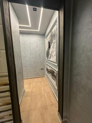 a hallway with a door leading into a room with paintings at MidtownTahrirViewSuites in Cairo