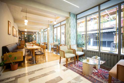 イスタンブールにある21 Rooms Hotelのテーブルと椅子と窓のあるレストラン