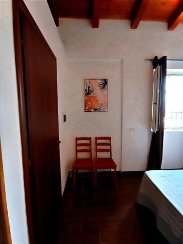two red chairs sitting in a room with a door at Polani - Il Noceto in Cave