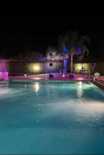a large swimming pool at night with lights at Focu e Mari in Mascali