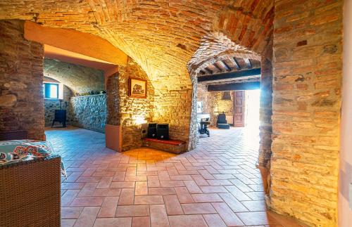 a stone hallway with a fireplace in a building at Tenuta Il Poggio - Luxury B&B in Felegara
