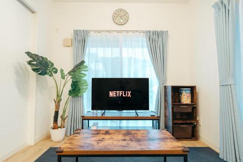 a living room with a table and a tv at Base in Onnason,Okinanawa in Onna
