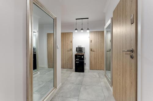 a hallway with a kitchen with a stove and a door at Grobla Centrum 3 by Grand Apartments in Gdańsk