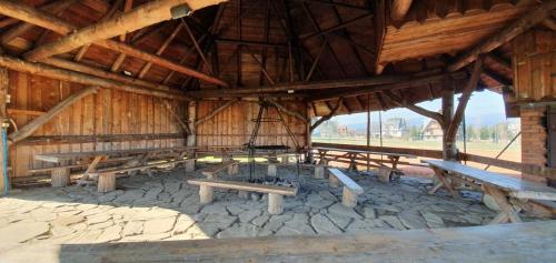 a group of picnic tables in a wooden building at Ośrodek Wczasowy Groń Placówka in Groń