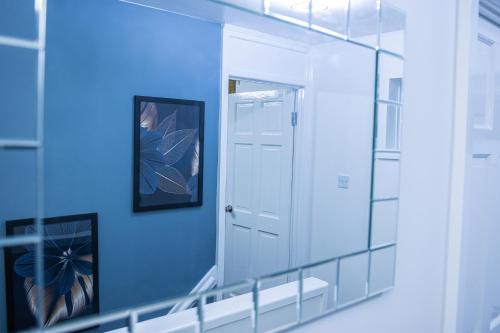 テルフォードにあるImpeccable 4-Bed House in Telford West Midlandsの鏡と青い壁の廊下