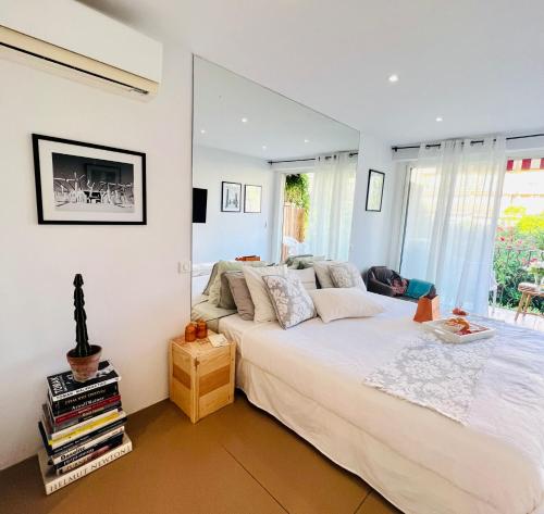 Un dormitorio con una gran cama blanca y una ventana en private room with balcony, en Saint-Tropez