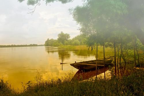 un pequeño barco sentado a un lado de un lago en Maison de campagne en cours de rénovation dans un village en bord de Loire, en Saint-Mathurin