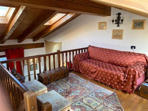una sala de estar con un sofá y una alfombra en Maison Sandy per 10 persone, en La Salle