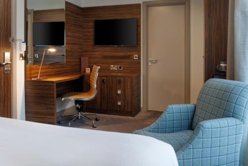 a hotel room with a desk and chairs and a television at DoubleTree by Hilton London Angel Kings Cross in London