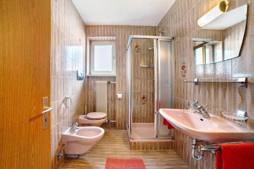 a bathroom with a sink and a shower and a toilet at Fröhlichhof Wohnung Apfelblüte in Lagundo