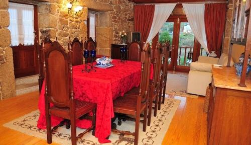 uma sala de jantar com uma mesa vermelha e cadeiras em Outros Tempos - Turismo de Aldeia em Armamar