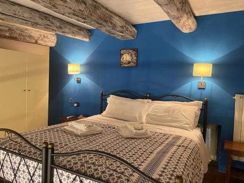 a blue bedroom with a bed with white pillows at Case Così Apartments - Napoli in Naples