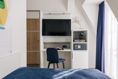 a bedroom with a bed and a desk with a television at Homaris East Side Hotel - Mobile Key Access in Berlin