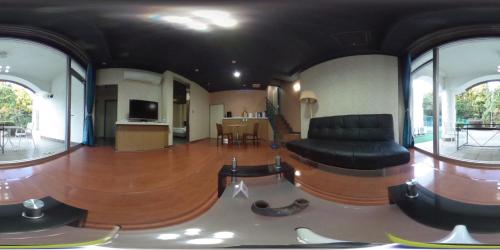 a living room with a black couch and a table at Higashi Kumamoto Business Center in Ozu
