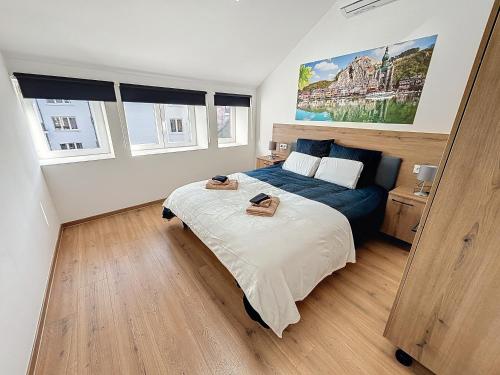 a bedroom with a bed in a room with windows at NOMAD APARTMENTS - Astrid in Dinant
