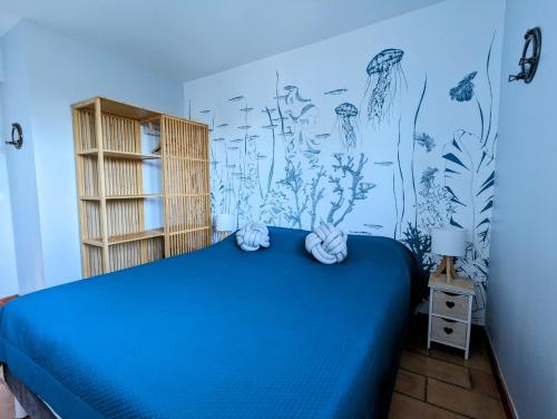 a bedroom with a blue bed and a mural of plants at Appartements L'Acacia - plage d'Argent à 300m in Coti-Chiavari