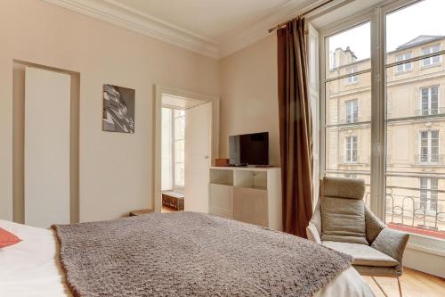 une chambre avec un lit, une chaise et une fenêtre dans l'établissement La Cathédrale - Versailles, à Versailles