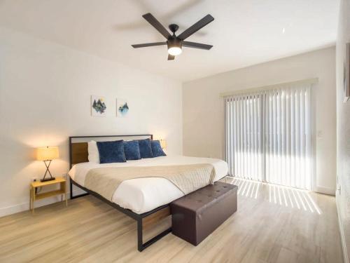 a bedroom with a bed with blue pillows and a ceiling fan at CozySuites Oasis at Kierland Commons in Scottsdale