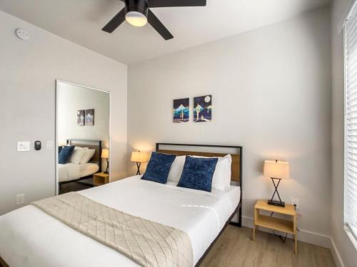 a bedroom with a large white bed with blue pillows at 2BR Kierland Commons Golf Oasis by CozySuites! in Scottsdale