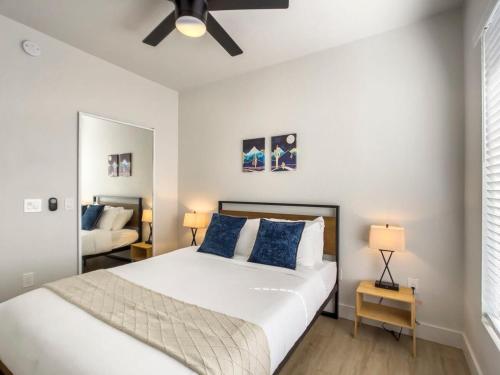 a bedroom with a large white bed with blue pillows at 2BR Kierland Commons CozySuites by the golf course in Scottsdale