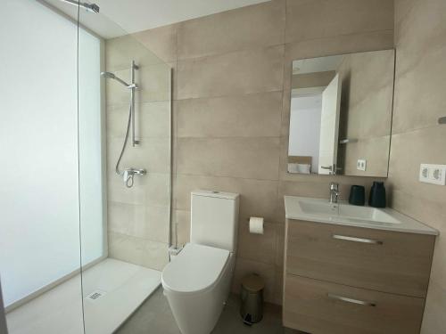 ein Badezimmer mit Toilette, Waschbecken und Dusche in der Unterkunft Aguja, Villa con piscina y barbacoa para disfrutar in Puerto Calero