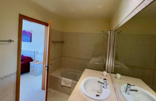 uma casa de banho com um lavatório e uma banheira em Vista das Ondas by Algarneto em Albufeira