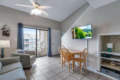 sala de estar con mesa, sillas y TV en Sugar Beach 319 condo, en Gulf Shores