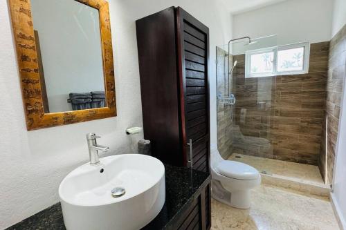 uma casa de banho com um lavatório, um WC e um chuveiro em Oceanfront Residence em Las Terrenas