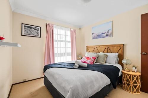 una camera con un grande letto e una finestra di Beautiful Home In Milperra Sleeps 8 a Sydney