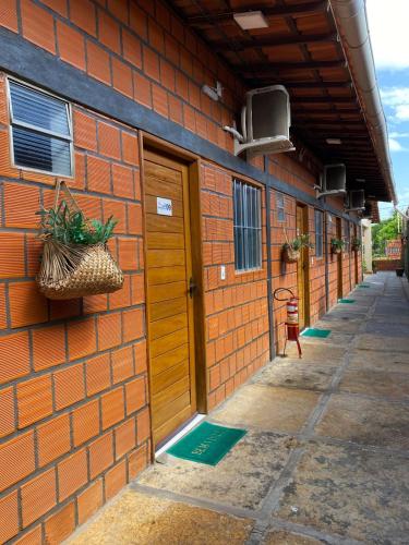 an orange brick building with a door on the side at POUSADA DOS LAGOS in Paulino Neves