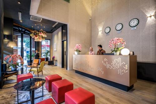 a lobby of a restaurant with people standing at a counter at Santa Grand Classic Kuala Lumpur, Chinatown in Kuala Lumpur