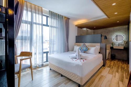 a bedroom with a bed and a chair and a large window at Santa Grand Classic Kuala Lumpur, Chinatown in Kuala Lumpur