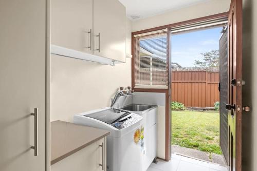 a kitchen with a sink and a dishwasher at Beautiful Home In Milperra Sleeps 8 in Sydney