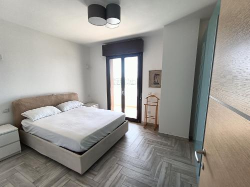 - une chambre avec un lit blanc et une fenêtre dans l'établissement Casa Fanna, à Su Forti