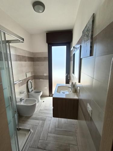 La salle de bains est pourvue de 2 toilettes, d'un lavabo et d'une douche. dans l'établissement Casa Fanna, à Su Forti