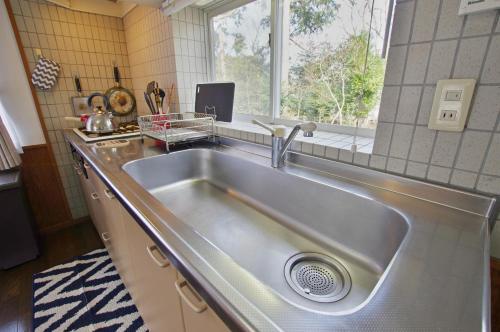 fregadero de acero inoxidable en una cocina con ventana en Villent Fujimi Hiekawa, en Izu