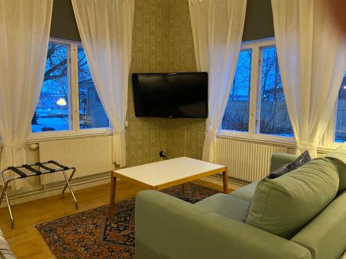 a living room with a couch and a tv at Borgs Villahotell och B&B in Norrköping