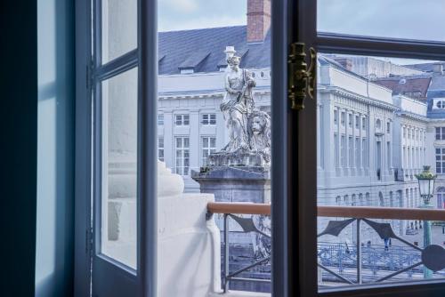 een standbeeld dat uit een raam naar een gebouw kijkt bij Juliana Hotel Brussels in Brussel