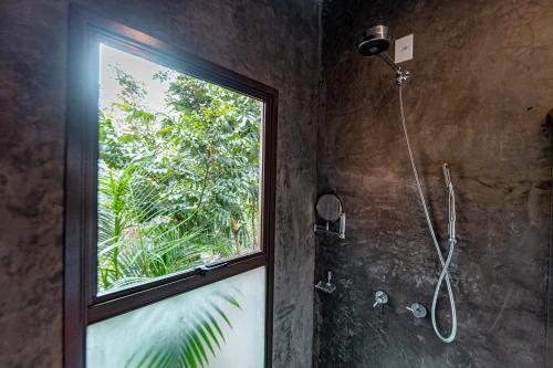 uma casa de banho com um chuveiro e uma janela em Quinta dos Goyazes Eco Boutique pra curtir a dois em Pirenópolis em Pirenópolis