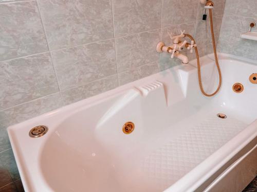 a white bath tub with a shower in a bathroom at Villa Nadya by GardaDoma in Brenzone sul Garda