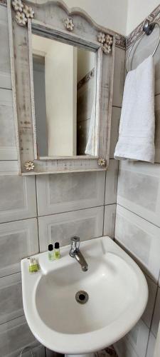 a bathroom with a white sink and a mirror at Suítes da Praça Tiradentes in Tiradentes