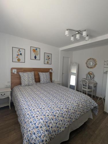 une chambre avec un lit avec une couette bleue et blanche dans l'établissement LA LOGIA DU SAPIN, à Villers-Allerand