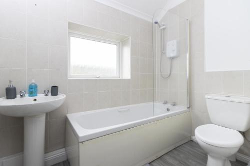a white bathroom with a toilet and a sink at OPP Plymouth - Large 3 bed, great WIFI and parking! BIG SAVINGS booking 7 nights or longer! in Plymouth