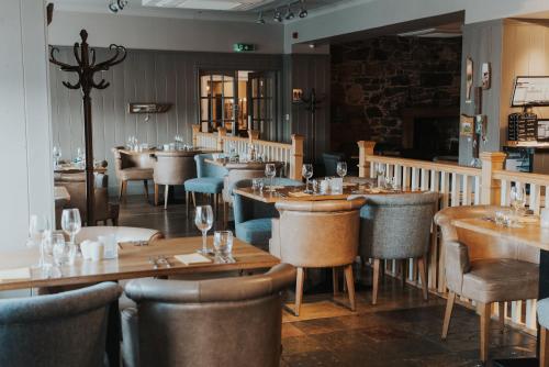 een eetkamer met houten tafels en stoelen bij Royal Hotel in Stornoway