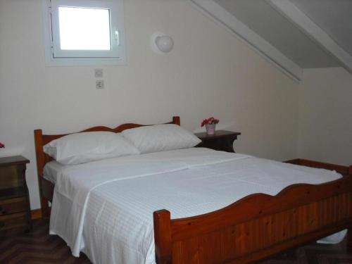 1 dormitorio con 1 cama grande y ventana en Kostas--Sarantis--2 en Lakithra
